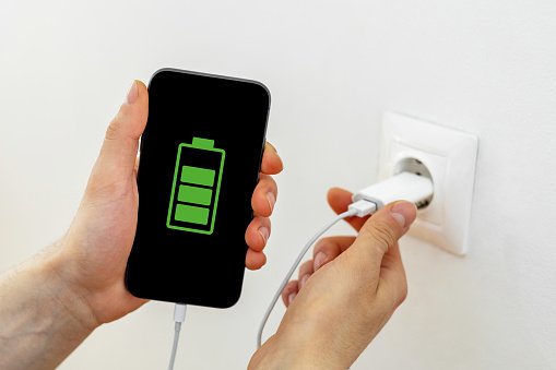 hands charging smart phone